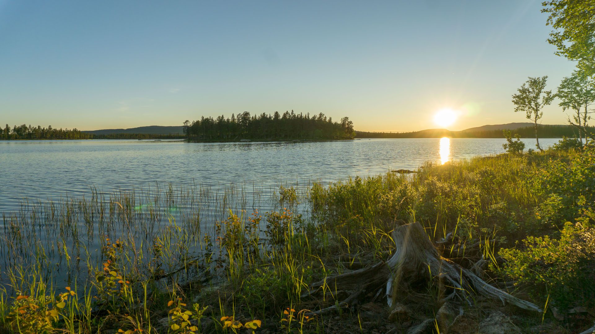 Mitternachtssonne in Schweden: tief stehende Sonne kurz vor Mitternacht über einem See in Lappland